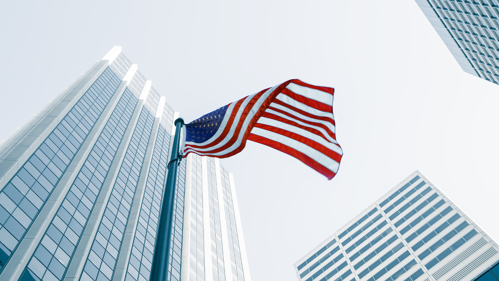 Bandera americana en medio de 3 edificios, sobrepasando un visado de EE.UU.