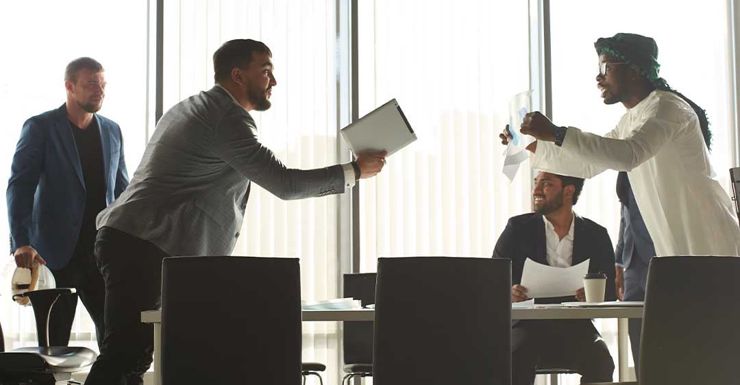 empresarios en medio de una disputa alrededor de una mesa de conferencias, resolviendo disputas entre miembros de la LLC,